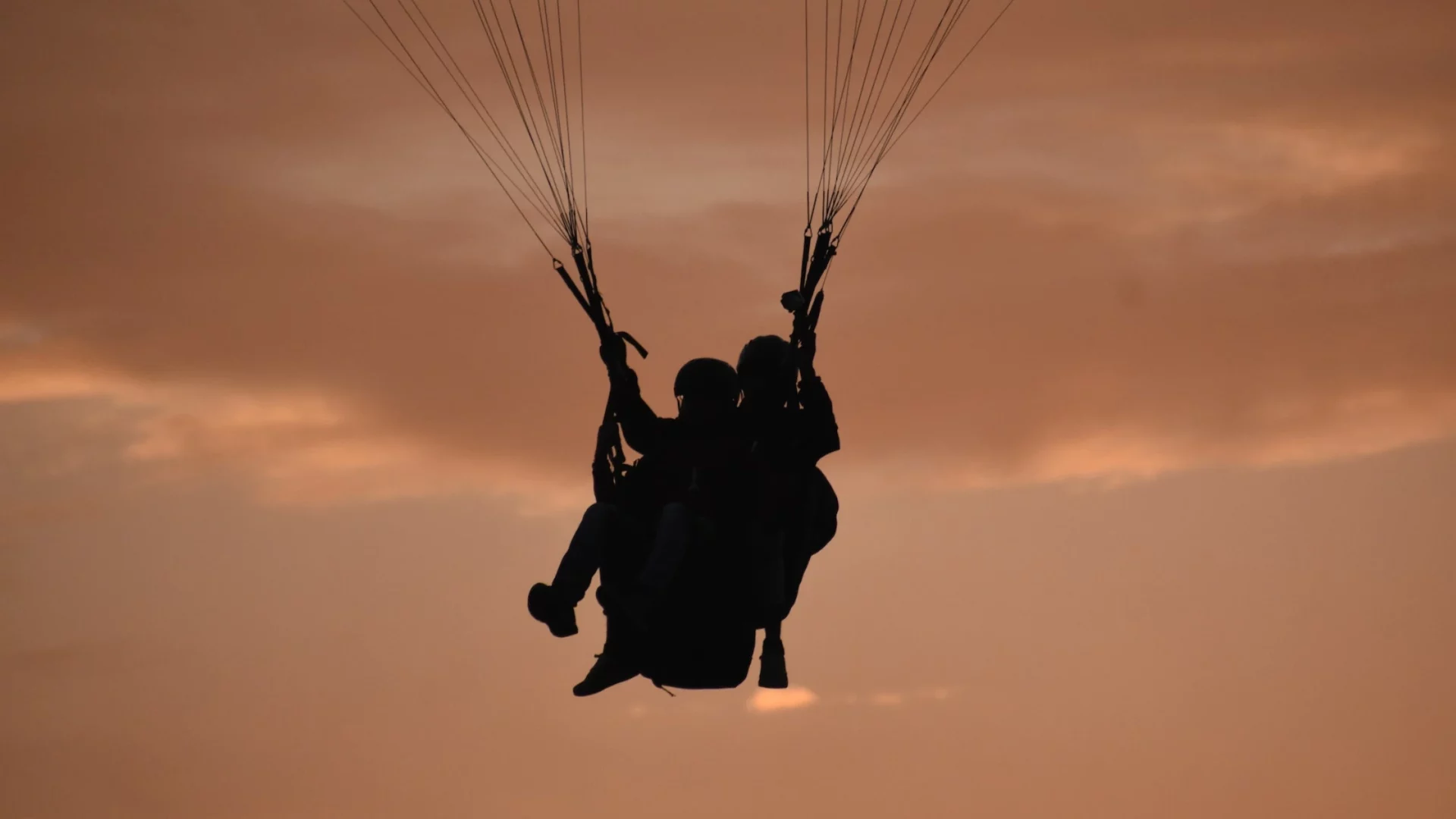 A tourist enjoying a tandem flight in a paraglider during his trip from Delhi to Bir Billing